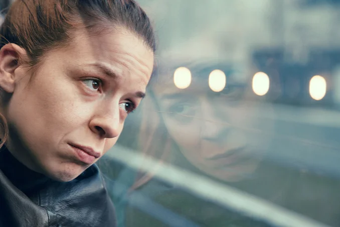 A woman looks out the window of her bus dramatically, not knowing how to choose a drug or alcohol rehab resources are available from Find Addiction Rehabs