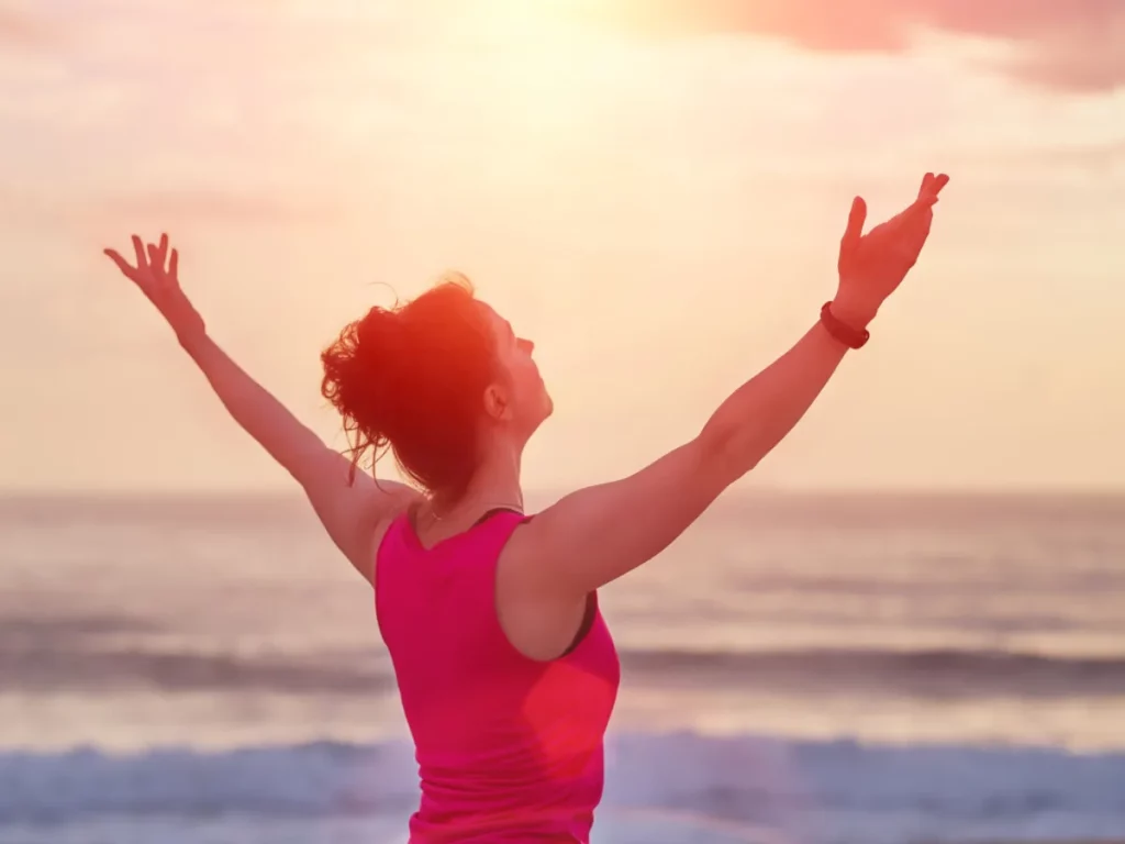 A woman does a Sun salutation after having found holistic drug rehab success