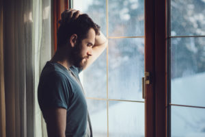 Trauma and Substance Abuse | Trauma and Addiction | Find Addiction Rehabs | Man looking out window contemplating trauma