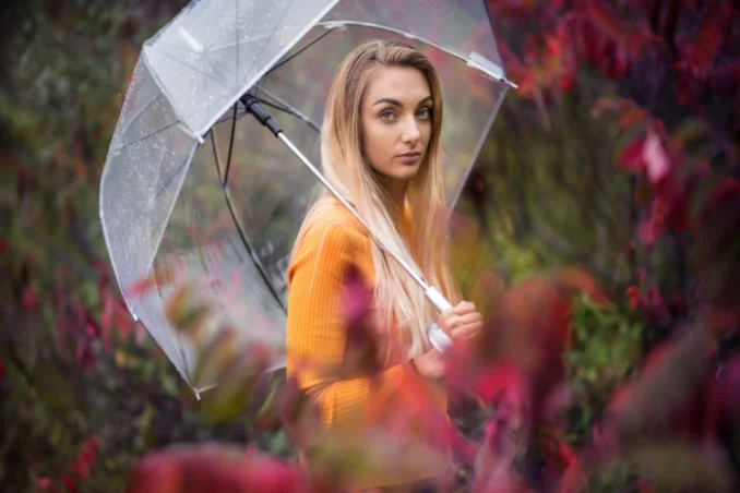 A young woman under an umbrella to show concept of protection from bad relationships while in rehab