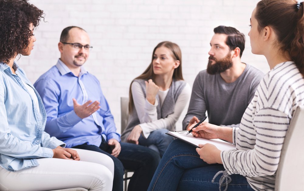 Addiction Aftercare - A group of people participates in a group counselling session during their addiction aftercare program.