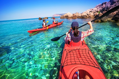 Relax in Sobriety - 2 kayaks paddle out into a cove with rock ledges and smooth, crystal clear water and a rocky bottom.