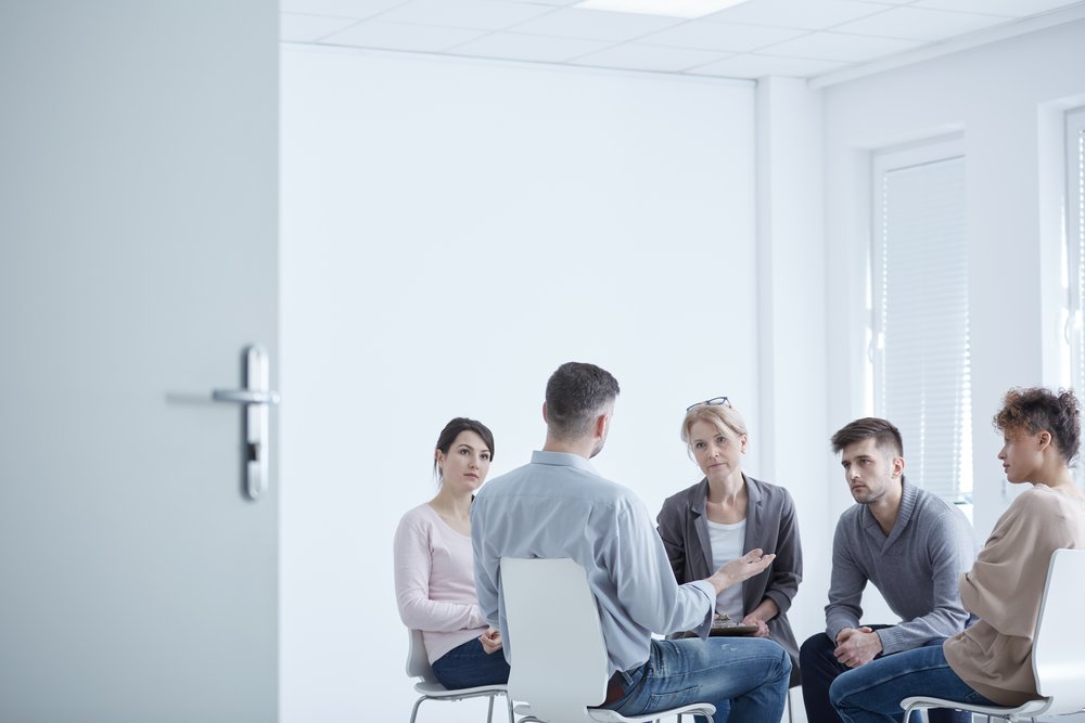 Addiction Treatment - Group of people sit in a circle during their group therapy for addiction treatment.