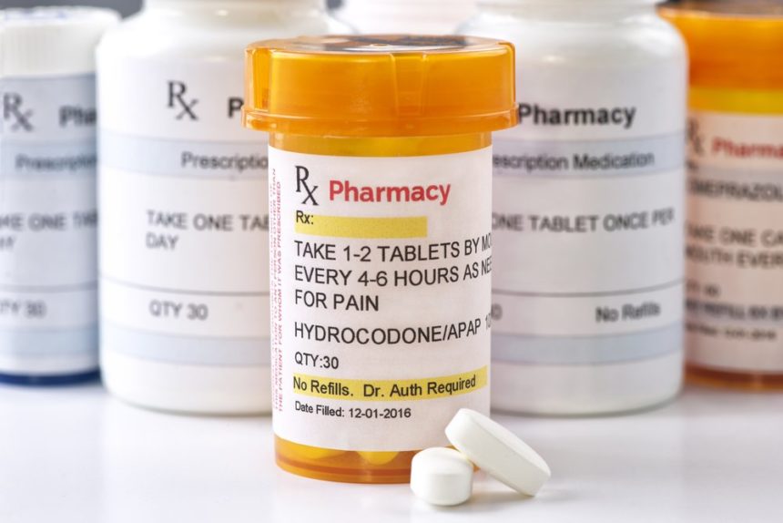 Painkillers, a close up photo of a bottle of Hydrocodone with several other prescription pill bottles behind it.