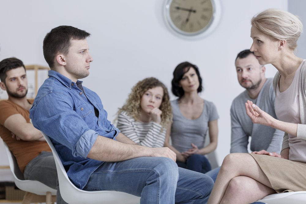 Program of Recovery - Small group of people sit in a circle during their group therapy at the addiction treatment center.