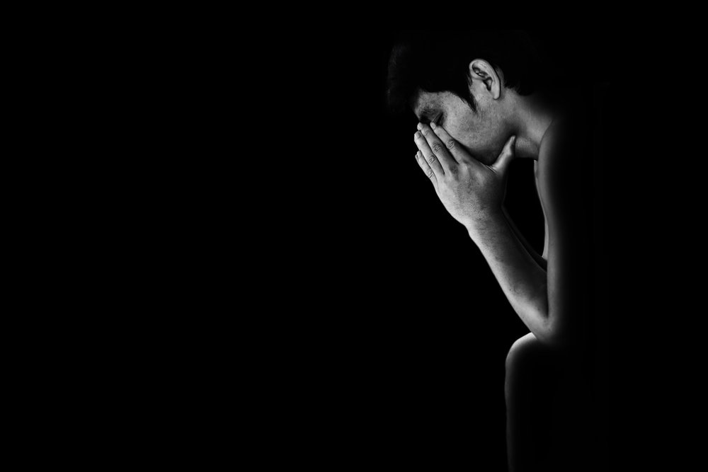 Rehab Romance - Black and white photo of a man from his side as he sits with his hands on his face. He is depressed because he is in addiction treatment and he broke up with another patient today. His rehab romance is over.