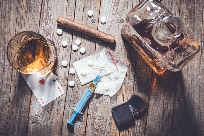 Drugs and alcohol arrayed on a table, indicating the need for Blue Cross Blue Shield coverage for drug rehab and alcohol rehab
