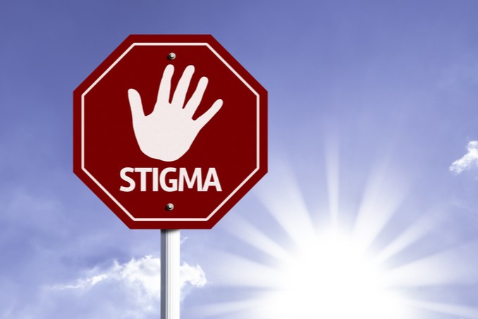 A stop sign with a hand, palm out, and the word 'STIGMA' to signify ending stigma of addiction