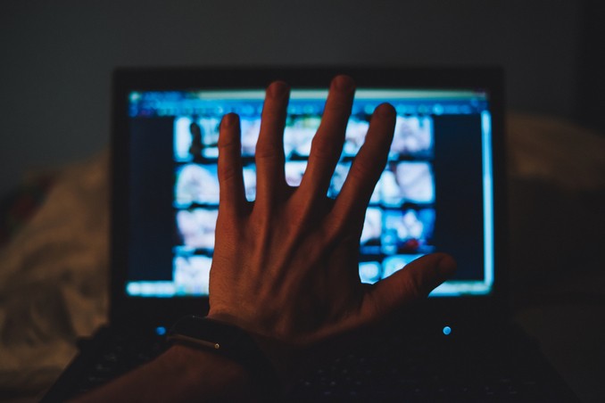 Hand in front of monitor showing blurry porn, to illustrate porn addiction recovery and stopping watching porn