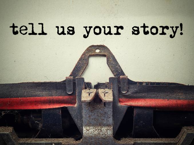 Typewriter with 'Tell us your story!' typed on page