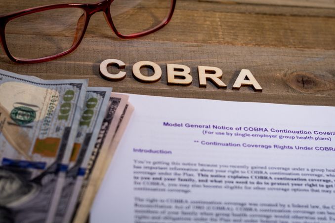 Word COBRA spelled out over paperwork and money, to indicate the possibility of the Act to help with rehabs that accept Beacon insurance