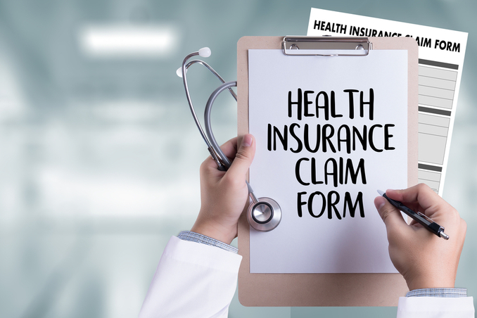 Hand holding clipboard with Health Insurance Claim Form, to show coverage with Cigna concept