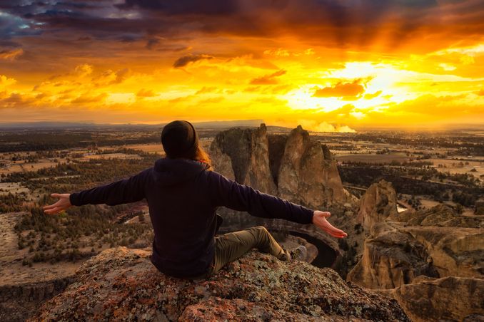 A man celebrates a glorious sunset, to show the concept of adventure therapy for addiction treatment in Oregon
