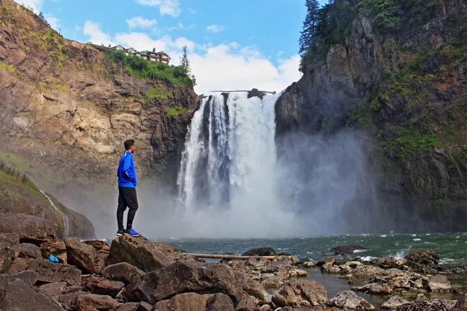 A man stares at a waterfall, to illustrate Washington has it all for people seeking assistance with a drug or alcohol problem: dynamic and engaging metropolitan cities, calm and therapeutic wilderness, and friendly recovery groups.