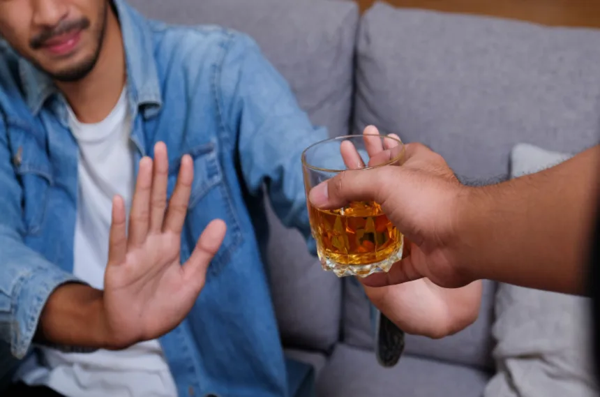 Alcohol addiction treatment as shown by man refusing a drink