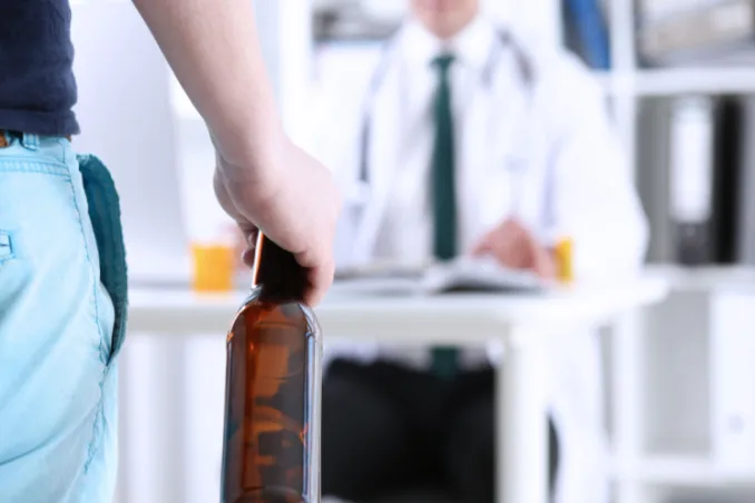 Man holds beer bottle in doctor office, concept pic on how to get insurance coverage for rehab