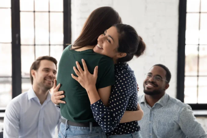 Women hug in group therapy to show concept of best rehab California