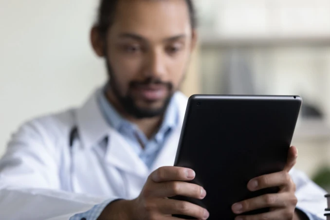A man looks at his tablet to determine types of addiction treatment coverage with Ambetter insurance