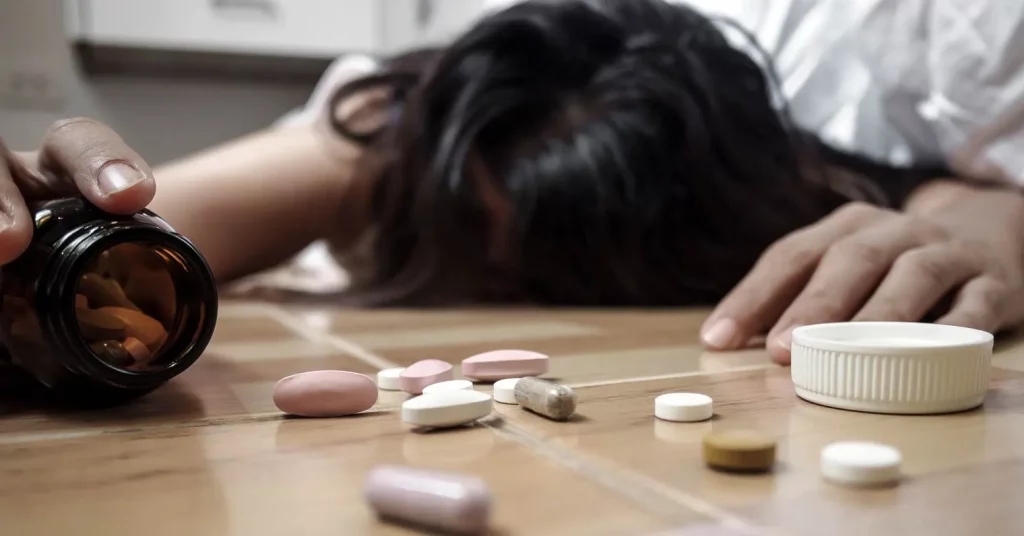 A young woman is lying on the floor with Overdose On Sleeping Pills
