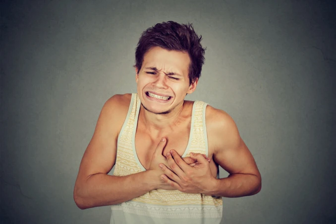 Meth overdose symptoms as shown by man clutching his chest near heart