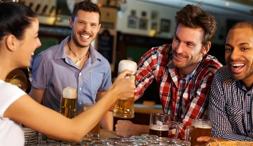 A group of friends drinking beer in pub